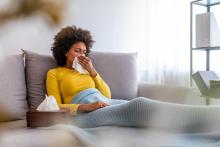 Woman inside blowing nose due to poor indoor air quality