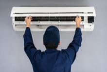 Technician replacing air conditioner