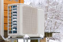 Heat pump condenser outside in the snow