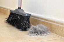 pile of dust on floor next to broom