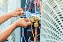 hands working on an air conditioner