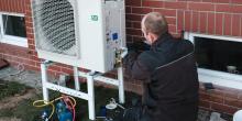 Worker installing heat pump in single family home