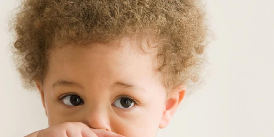 Small boy wiping his nose with his hand