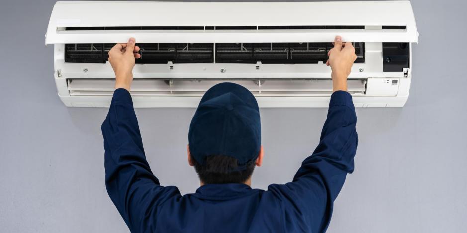 Technician replacing air conditioner