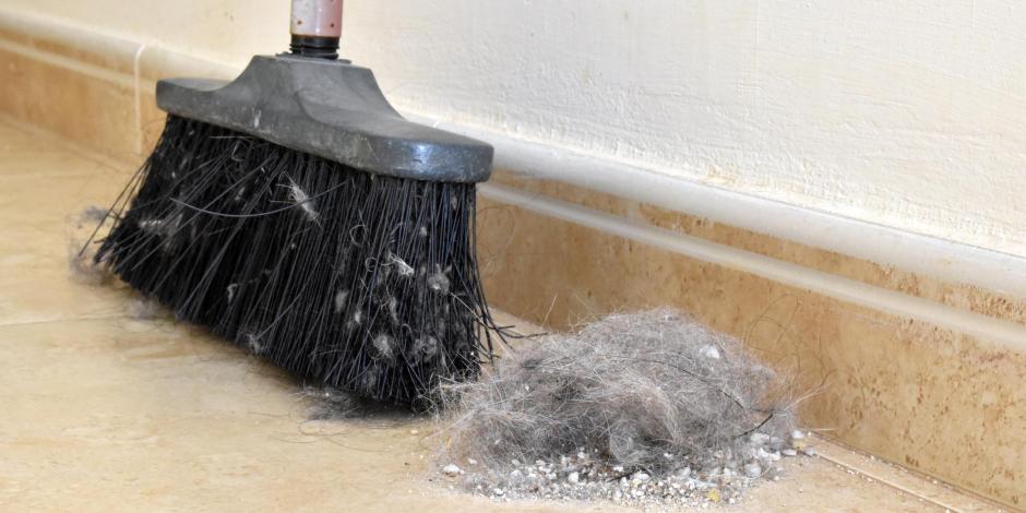 pile of dust on floor next to broom