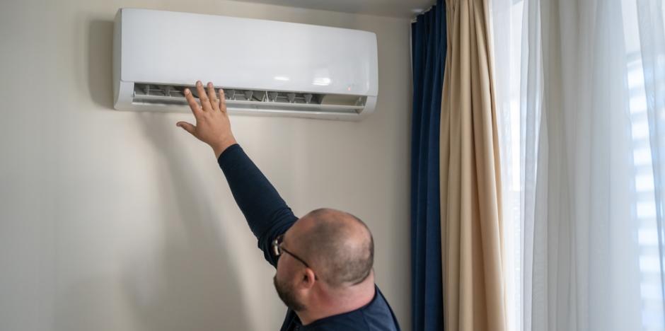 man checking to see if AC is broken
