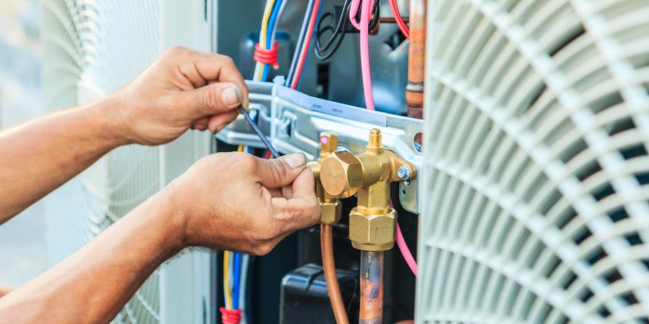 hands working on an air conditioner